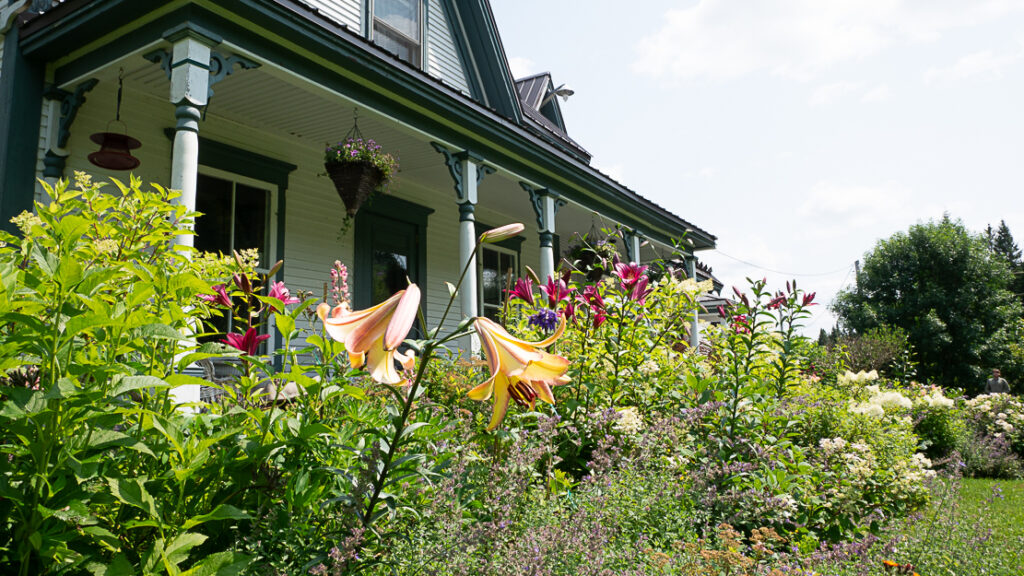 The ccdMalvina farmhouse surrounded by summer flowers in Saint-Malo, Eastern Townships